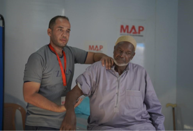 A man receiving physio on his shoulder and arm from a medical professional at MAP's Solidarity Polyclinic