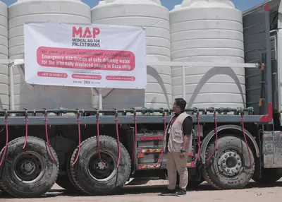A MAP aid worker stands next to a water-trucking lorry carrying thousands of litres of clean drinking water in Gaza.