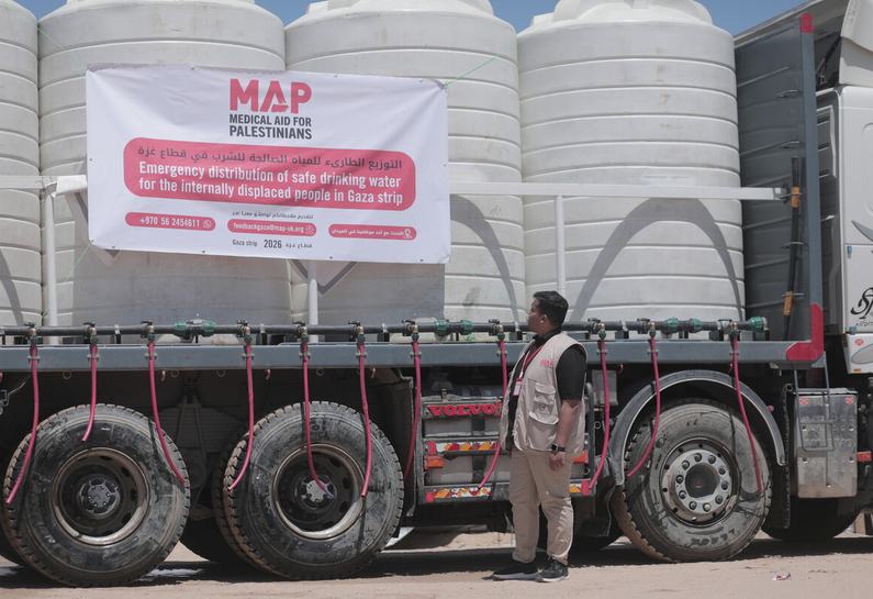 A MAP aid worker stands next to a water-trucking lorry carrying thousands of litres of clean drinking water in Gaza.