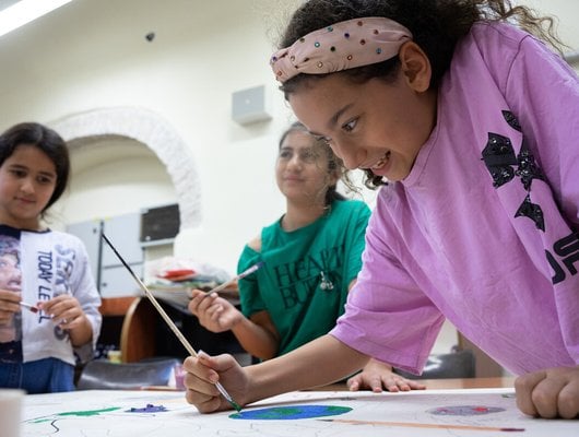 A girl doing painting a picture and smiling