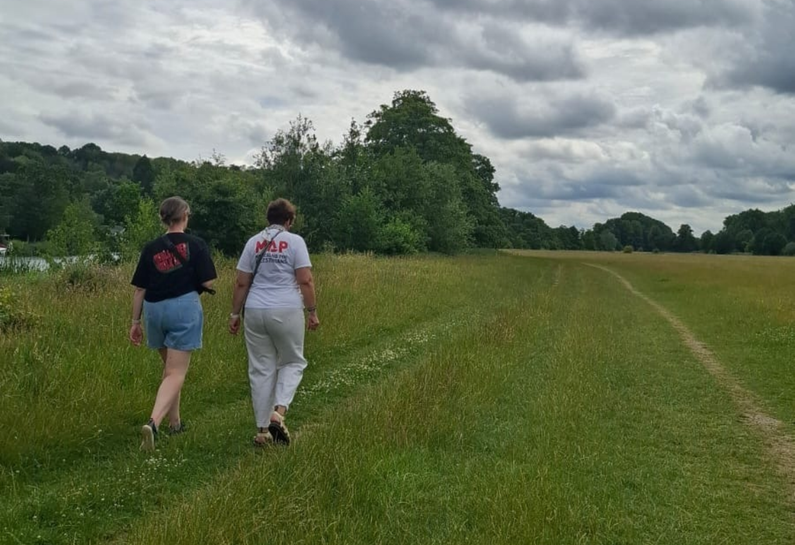 Photo from behind of Lynette Murray walking with a friend for MAP's Stride for Palestinians event, wearing a Medical Aid for Palestinians t-shirt.