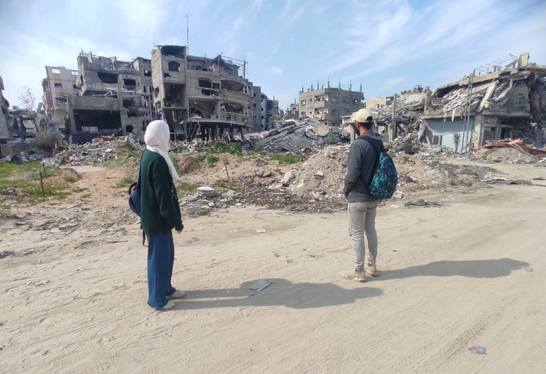Mona and her brother, Mahmoud, looking out to destroyed neighbourhood in Gaza.