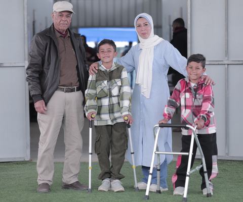 Photo of Yaqoub and Murad with their aunt, Abeer, and grandfather, Sobhi Shehab, at MAP's Solidarity Polyclinic in Deir al-Balah.