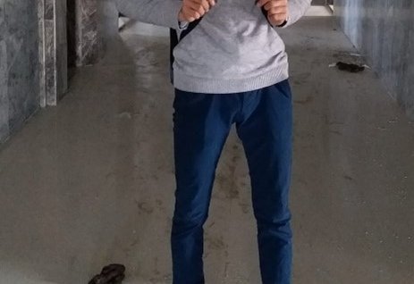 Ahmad standing, on his way to work