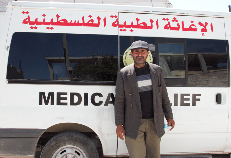 A community member in front of the mobile clinic van
