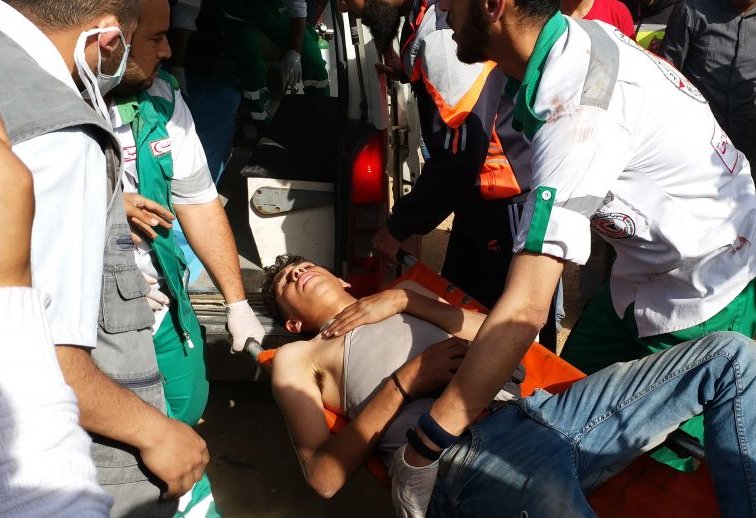 An injured man is carried by medics on a stretcher