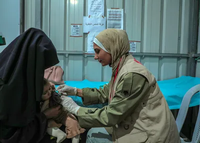Zaina Al-Ghalayini, Community Health Worker at the Solidarity Polyclinic in Gaza checking up on a small child.