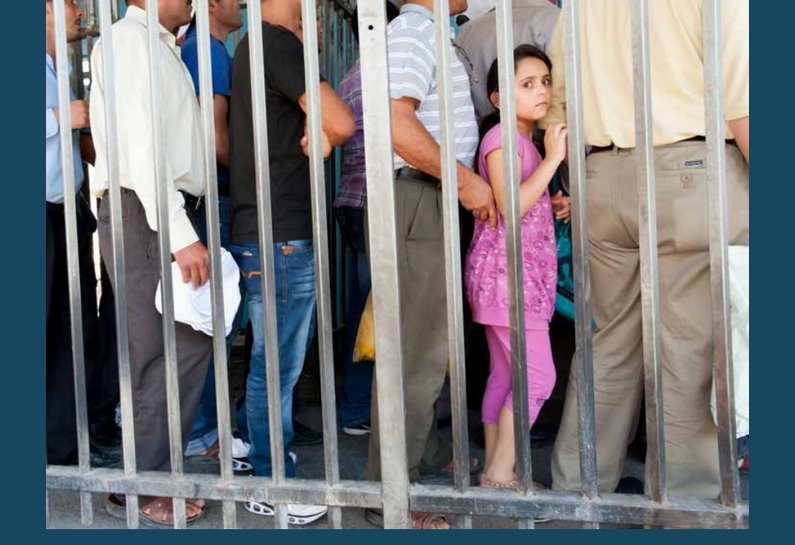 A scene suggesting a crowded checkpoint or controlled entry area, with limited space and people holding papers or bags as they wait to move forward.